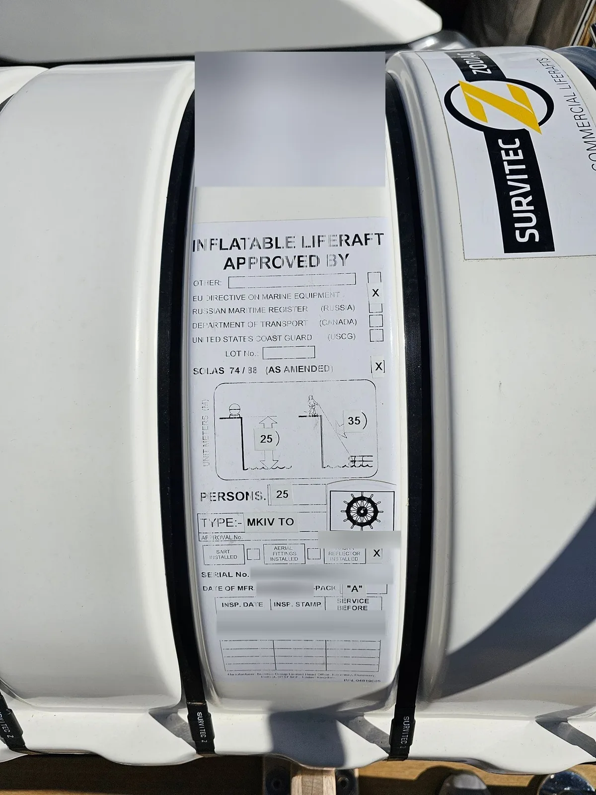The approval label on a liferaft canister. The serial number, dates and service label are blurred.